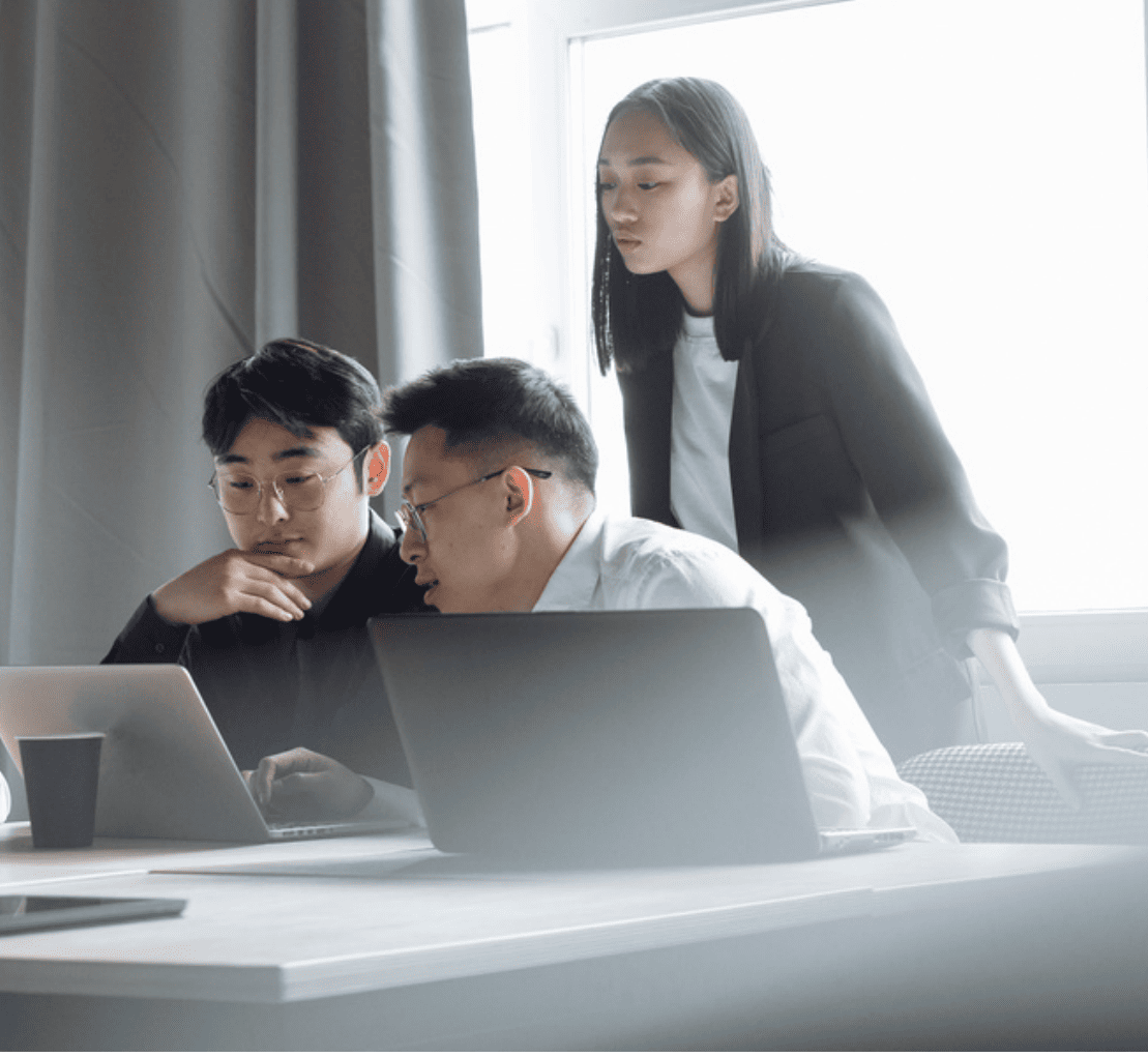software-chain-of-custody Software Chain of Custody: 3 workers looking over laptop in collaborative environment